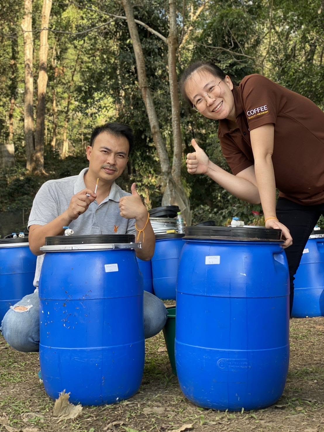 Das Chillrista-Team mit blauen Fermentationsfässern für Kaffee in Chiang Rai